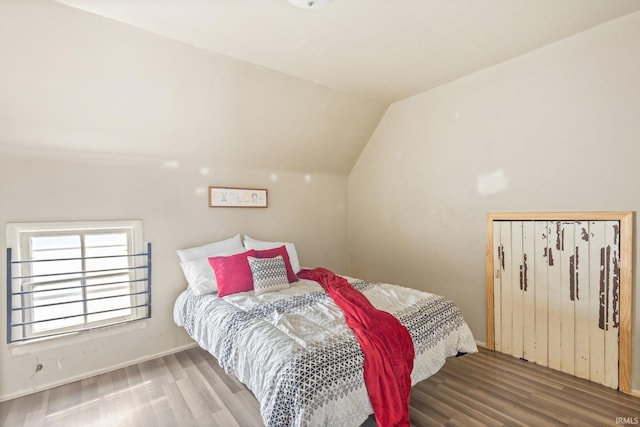 bedroom with vaulted ceiling and hardwood / wood-style floors