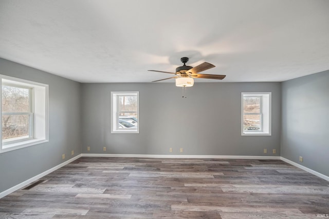 unfurnished room with a wealth of natural light, ceiling fan, and light hardwood / wood-style flooring