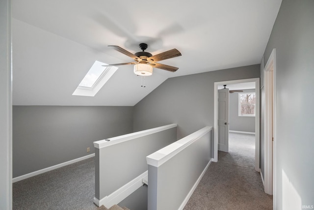 corridor with lofted ceiling with skylight and carpet