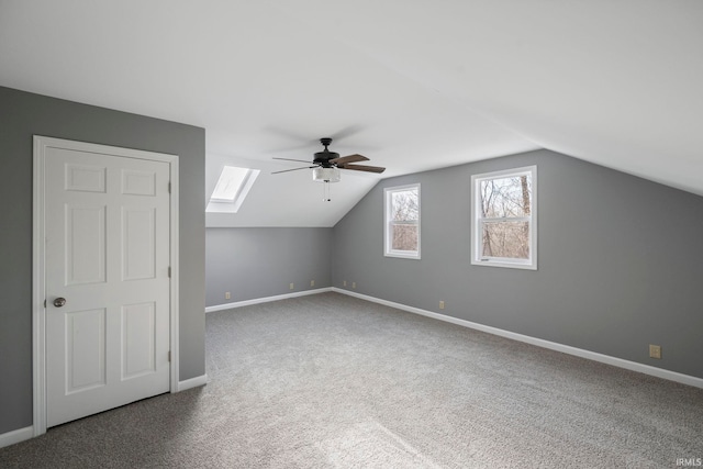 bonus room featuring lofted ceiling with skylight, ceiling fan, and carpet