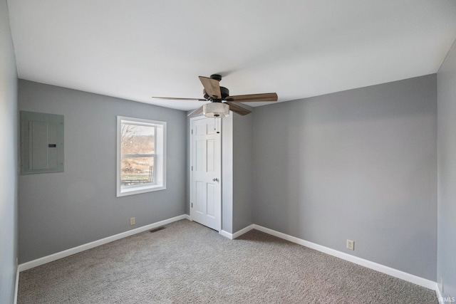 carpeted spare room with ceiling fan and electric panel