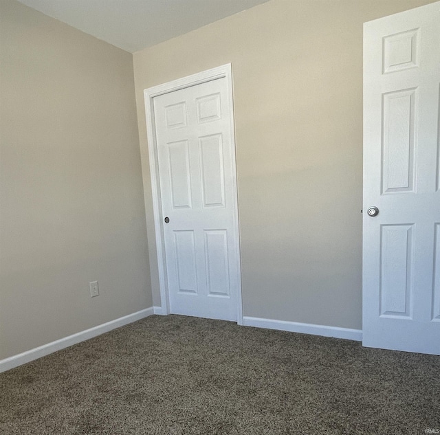 unfurnished bedroom with dark carpet