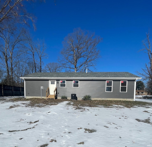 snow covered rear of property with central air condition unit