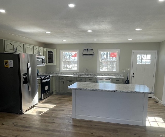 kitchen with stainless steel appliances, sink, hardwood / wood-style floors, and plenty of natural light