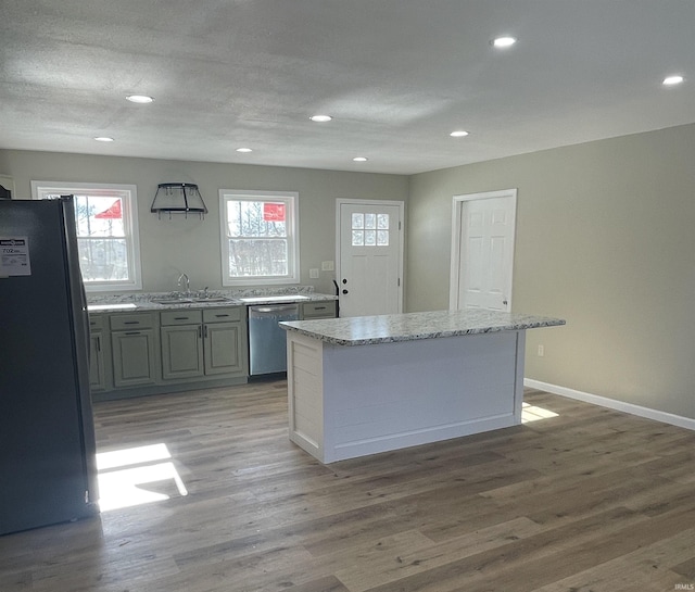 kitchen featuring sink, gray cabinetry, a center island, light wood-type flooring, and appliances with stainless steel finishes