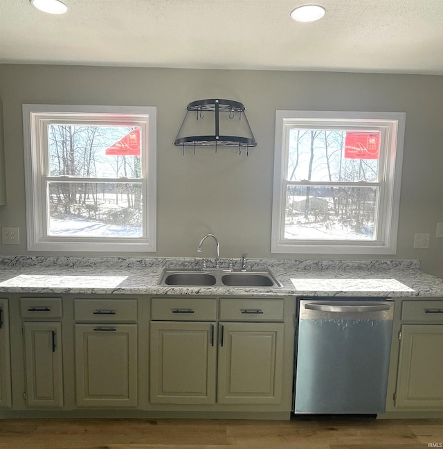 kitchen featuring green cabinetry, dishwasher, sink, and light wood-type flooring