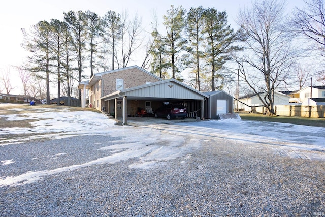 view of home's exterior with a garage, an outdoor structure, and a carport