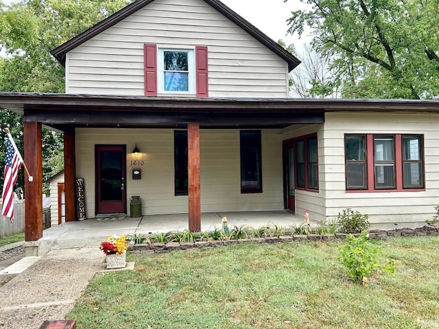 view of front of home featuring covered porch and a front lawn