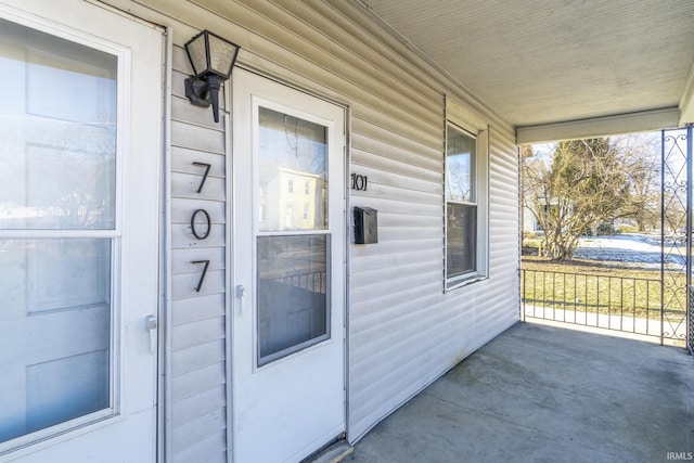 view of exterior entry featuring covered porch