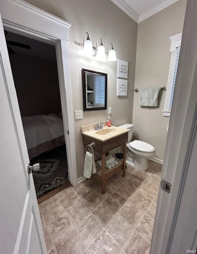 bathroom with crown molding, vanity, and toilet