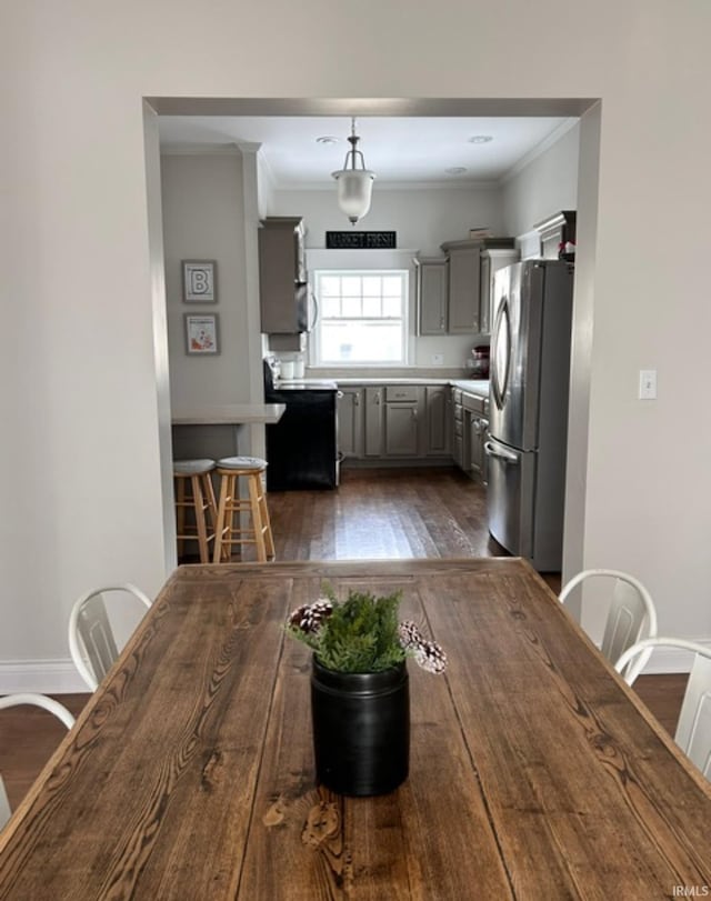 unfurnished dining area with ornamental molding and dark hardwood / wood-style flooring