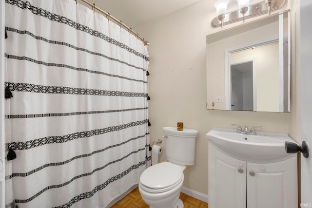 bathroom with vanity, parquet flooring, toilet, and walk in shower