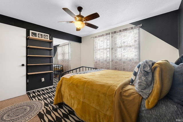 bedroom with a textured ceiling, ceiling fan, and carpet