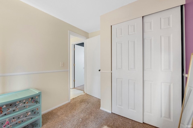 unfurnished bedroom featuring light colored carpet and a closet