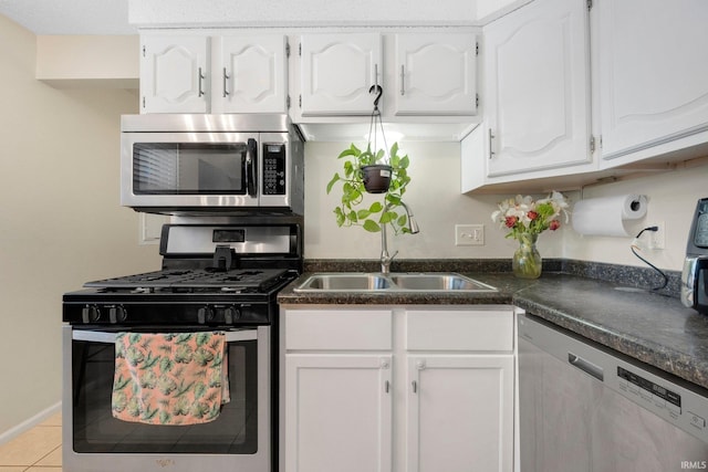 kitchen with white cabinetry, stainless steel appliances, sink, and light tile patterned floors