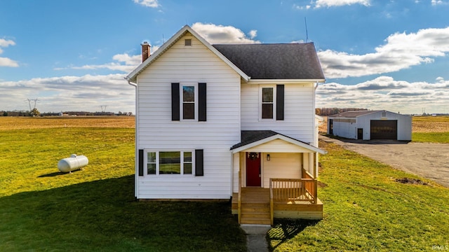 view of front of home with a garage, an outdoor structure, and a front yard