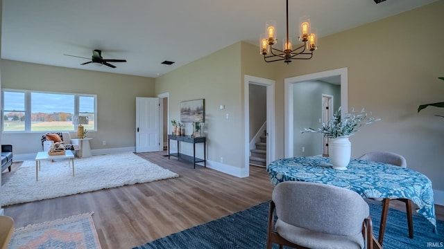 interior space with hardwood / wood-style floors and ceiling fan with notable chandelier