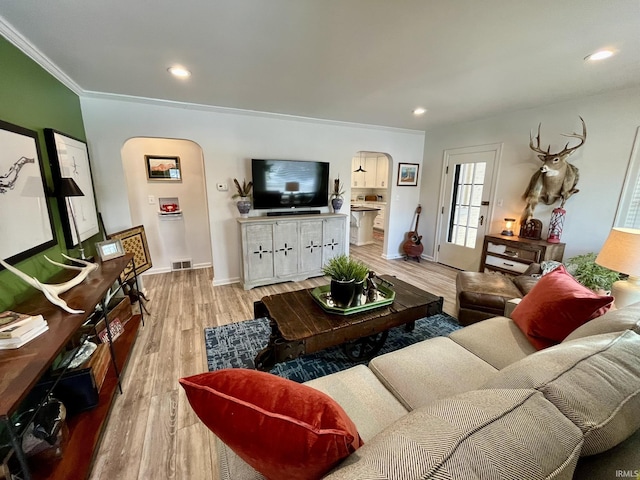 living room featuring crown molding and light hardwood / wood-style floors