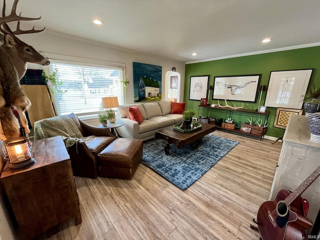 living room with crown molding and light hardwood / wood-style flooring