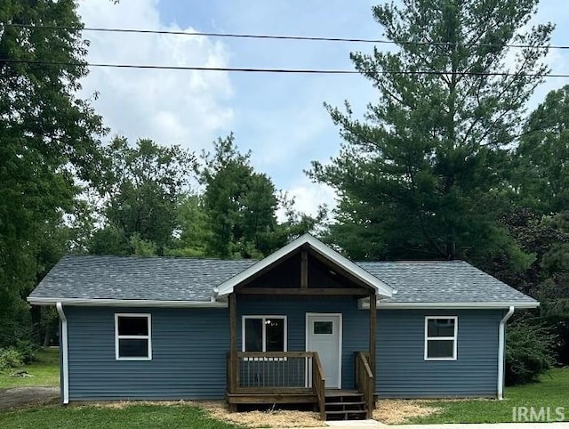 view of front of house with a wooden deck and a front yard