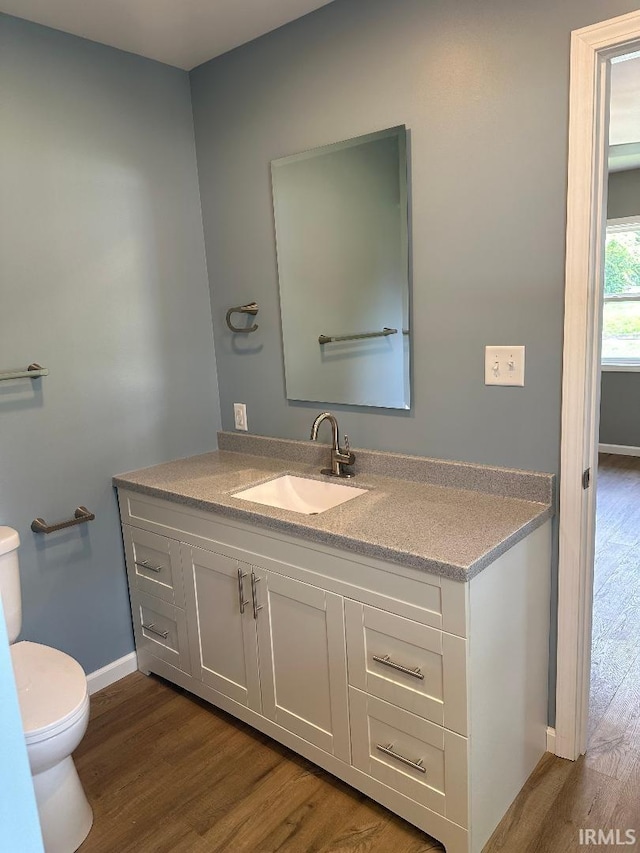 bathroom featuring vanity, hardwood / wood-style flooring, and toilet