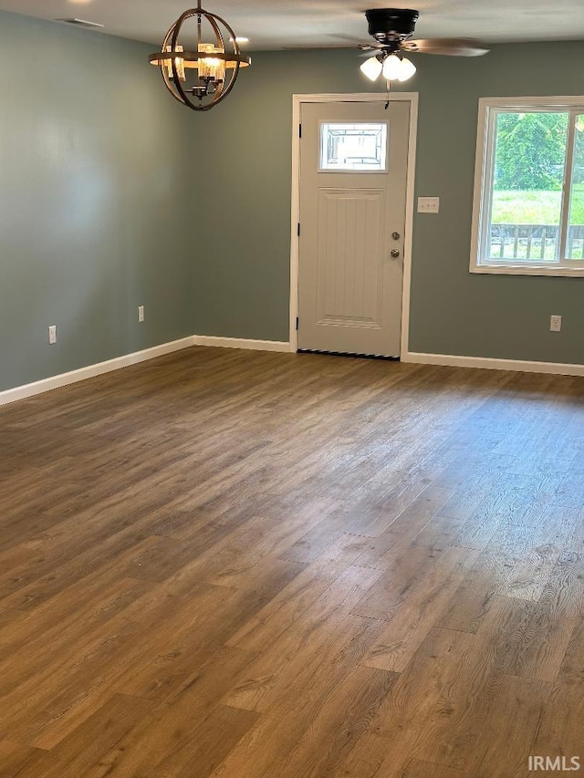 foyer entrance with hardwood / wood-style floors, ceiling fan with notable chandelier, and a wealth of natural light