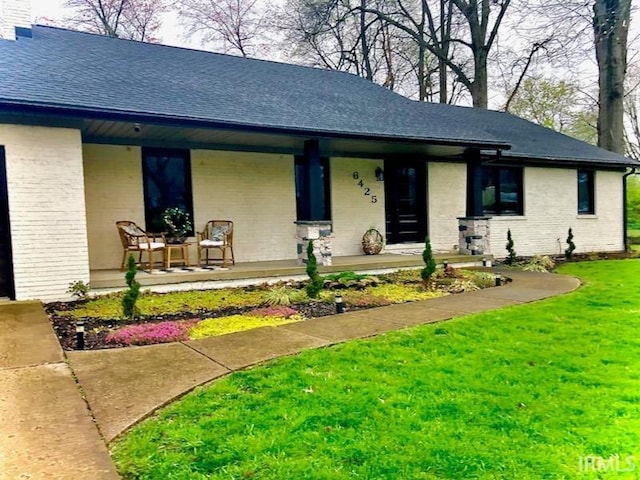 view of front of house featuring covered porch and a front yard