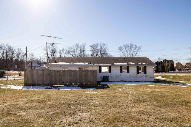 back of property with central AC unit and a yard