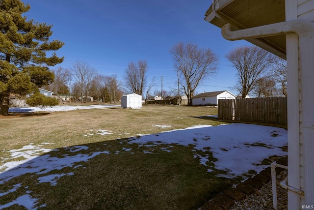 snowy yard featuring a storage unit