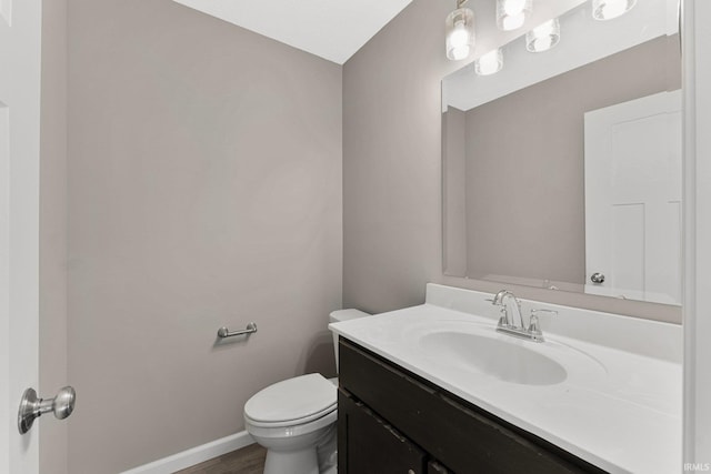 bathroom featuring vanity, hardwood / wood-style flooring, and toilet