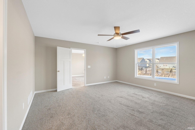 spare room featuring ceiling fan and carpet