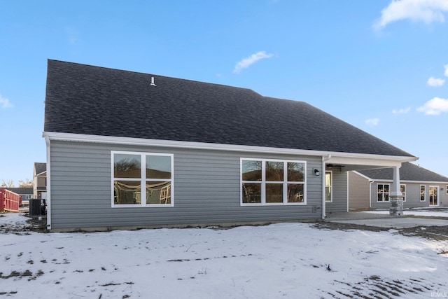 snow covered property featuring central AC unit