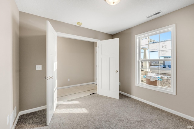 unfurnished bedroom with light colored carpet