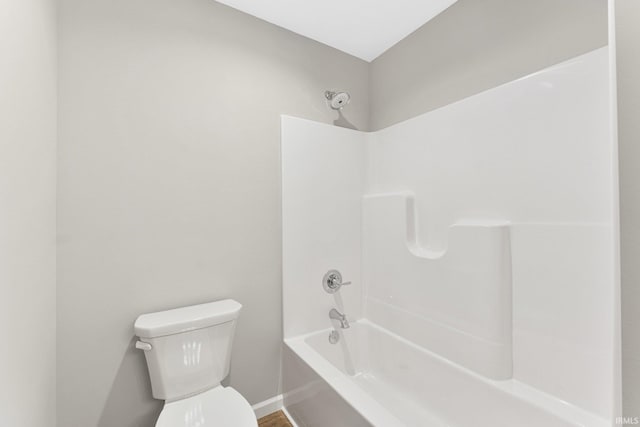 bathroom featuring shower / tub combination and toilet