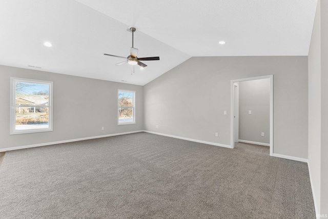 carpeted spare room featuring vaulted ceiling and ceiling fan