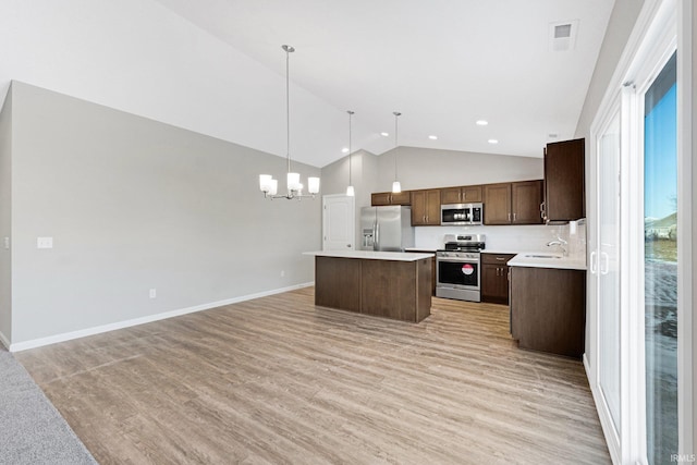 kitchen featuring a center island, a chandelier, hanging light fixtures, light wood-type flooring, and stainless steel appliances