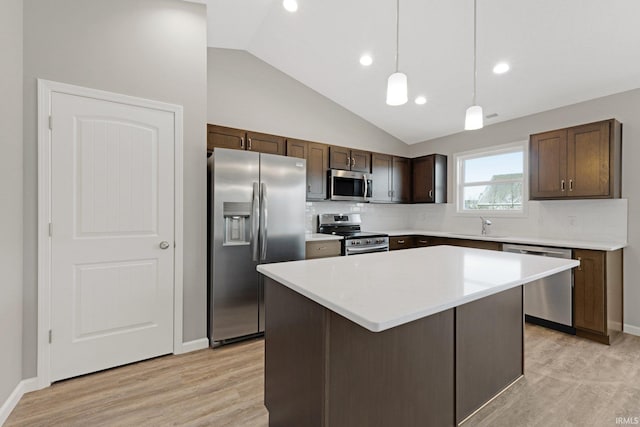 kitchen featuring sink, hanging light fixtures, stainless steel appliances, dark brown cabinetry, and a kitchen island