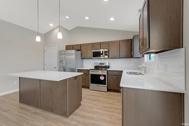 kitchen featuring pendant lighting, sink, backsplash, a center island, and stainless steel appliances