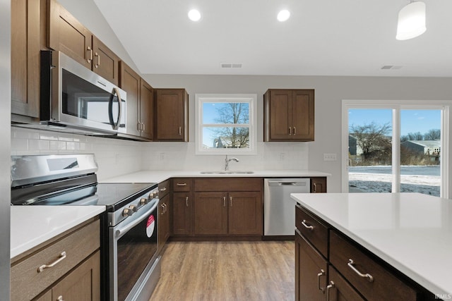 kitchen featuring tasteful backsplash, sink, stainless steel appliances, and a healthy amount of sunlight