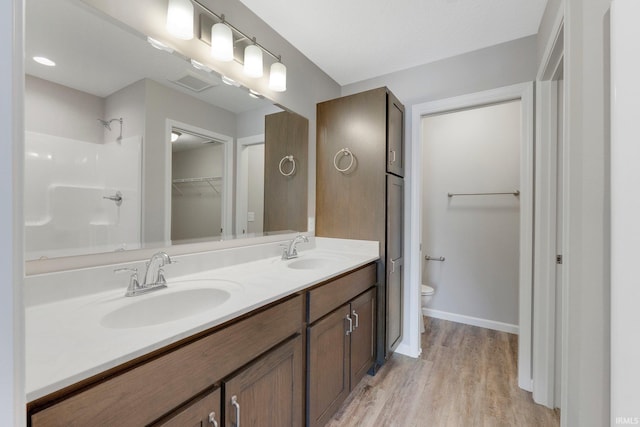 bathroom with vanity, toilet, and hardwood / wood-style floors