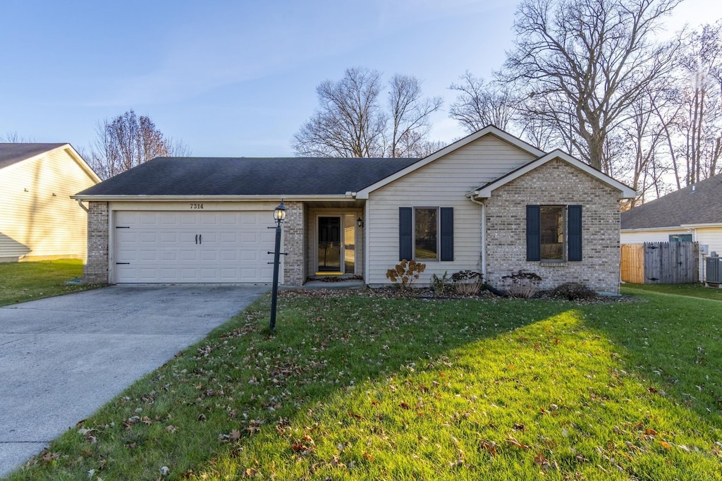 single story home with a garage, central air condition unit, and a front lawn