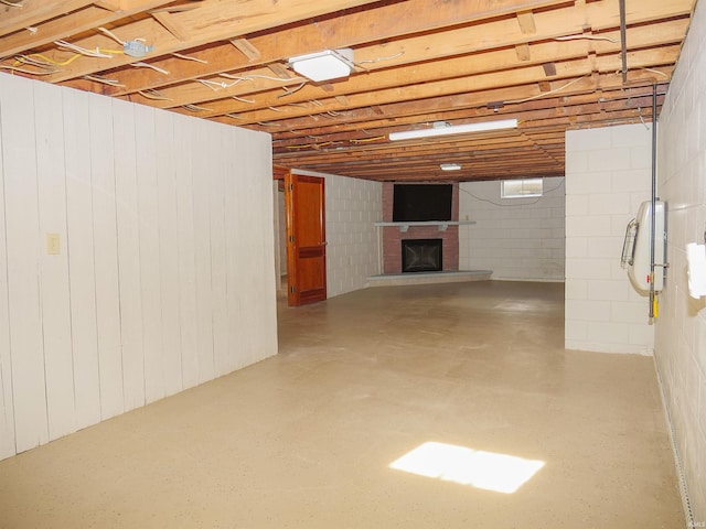 basement with a fireplace and wood walls