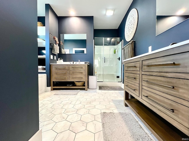 bathroom featuring a shower with door and vanity