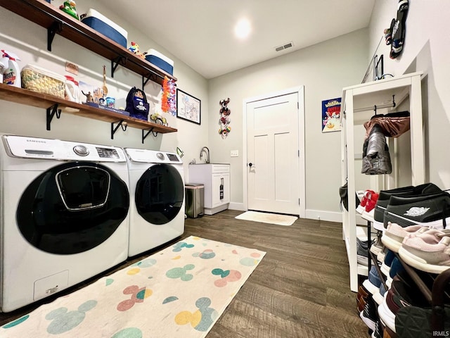 laundry room with cabinets, dark hardwood / wood-style flooring, and washer and clothes dryer