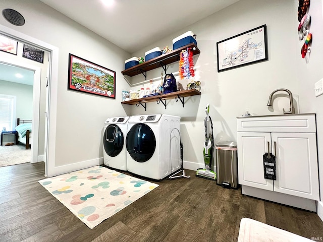 laundry room with cabinets, washer and dryer, and dark hardwood / wood-style floors