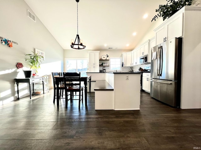 kitchen featuring stainless steel appliances, pendant lighting, white cabinets, and decorative backsplash