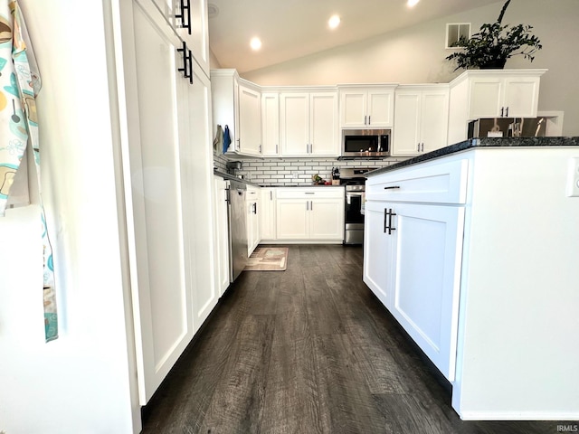 kitchen featuring stainless steel appliances, vaulted ceiling, and white cabinets