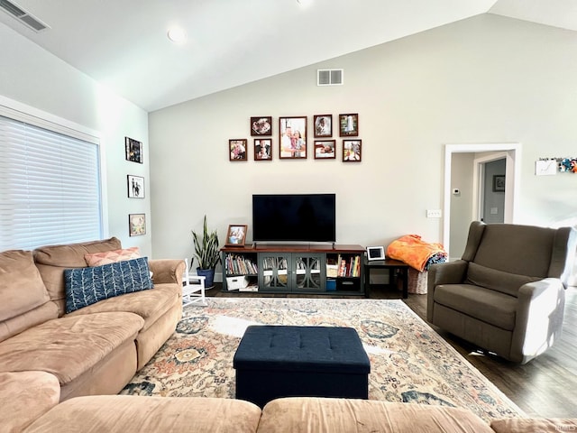 living room with dark hardwood / wood-style flooring and high vaulted ceiling