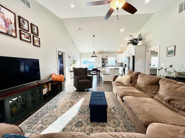 living room with ceiling fan, dark hardwood / wood-style floors, and high vaulted ceiling