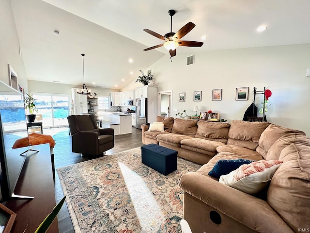 living room featuring ceiling fan with notable chandelier, hardwood / wood-style floors, and high vaulted ceiling